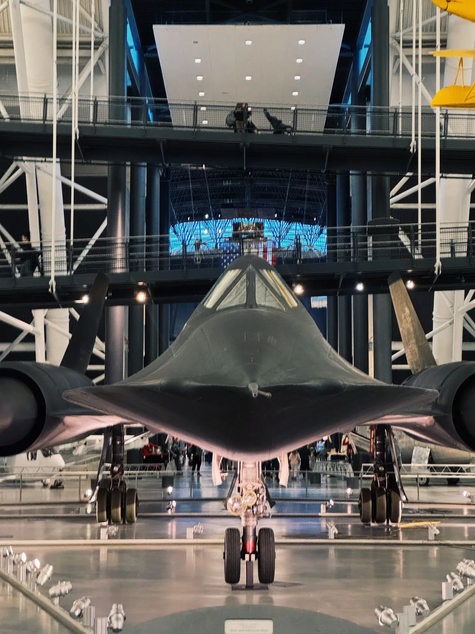 An SR-71 Blackbird, nose on, in a museum hangar.